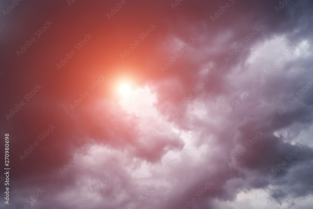 Epic scenic storm dark clouds background with sun and orange sunlight. Darkness and light	