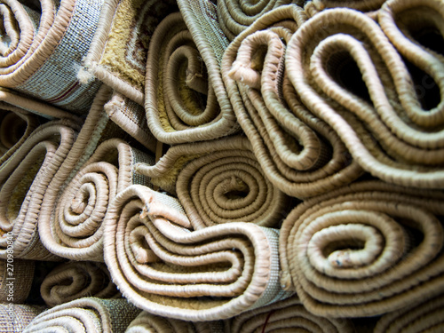 Rolled up carpets are stacked on the rack warehouse
