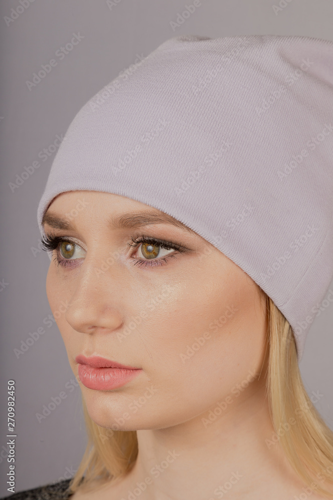 Beautiful girl with natural make-up in a headdress on a gray background. Beautiful girl with natural make-up in a headdress on a gray background.