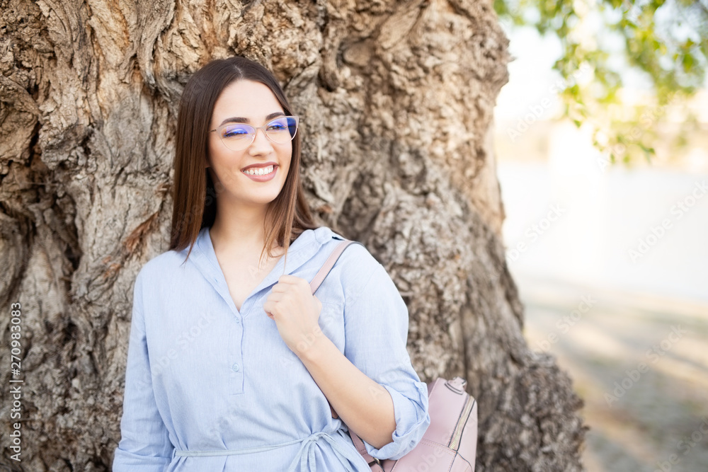 Young woman with glasses smiling and posing for a camera Young woman with glasses smiling and posing for a camera