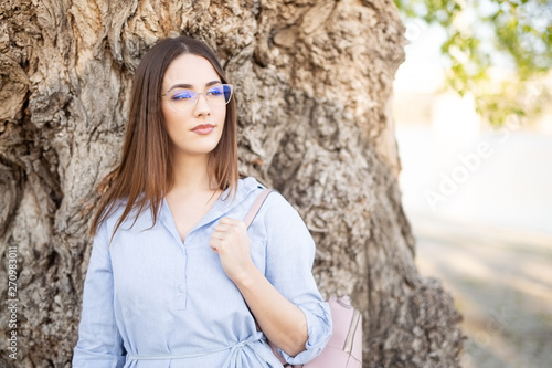Young woman with glasses posing for a camera outdoors © bokan
