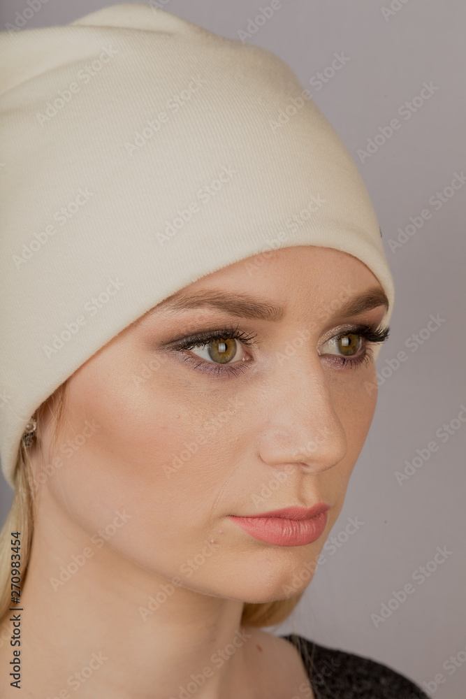 Beautiful girl with natural make-up in a headdress on a gray background. Beautiful girl with natural make-up in a headdress on a gray background.