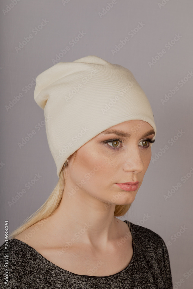 Beautiful girl with natural make-up in a headdress on a gray background. Beautiful girl with natural make-up in a headdress on a gray background.