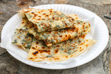 Gozleme. A traditional dish of Turkish cuisine in the form of flatbread stuffed with greens and cheese, wrapped inside. Baked in a pan called a saj. Selective focus
