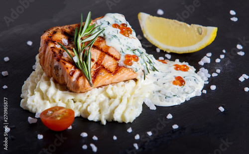 salmon with mashed potatoes on black table