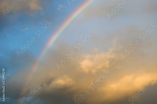 colorful rainbow in sunset cloudy sky © Vladyslav Siaber