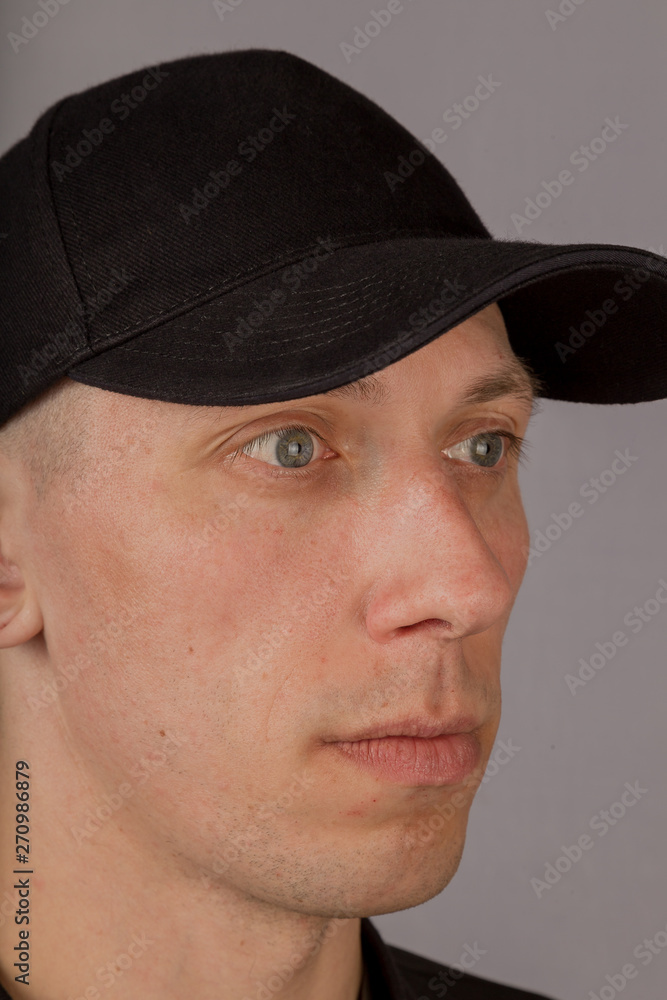 Handsome young man in a headdress on a gray background. Handsome young man in a headdress on a gray background.
