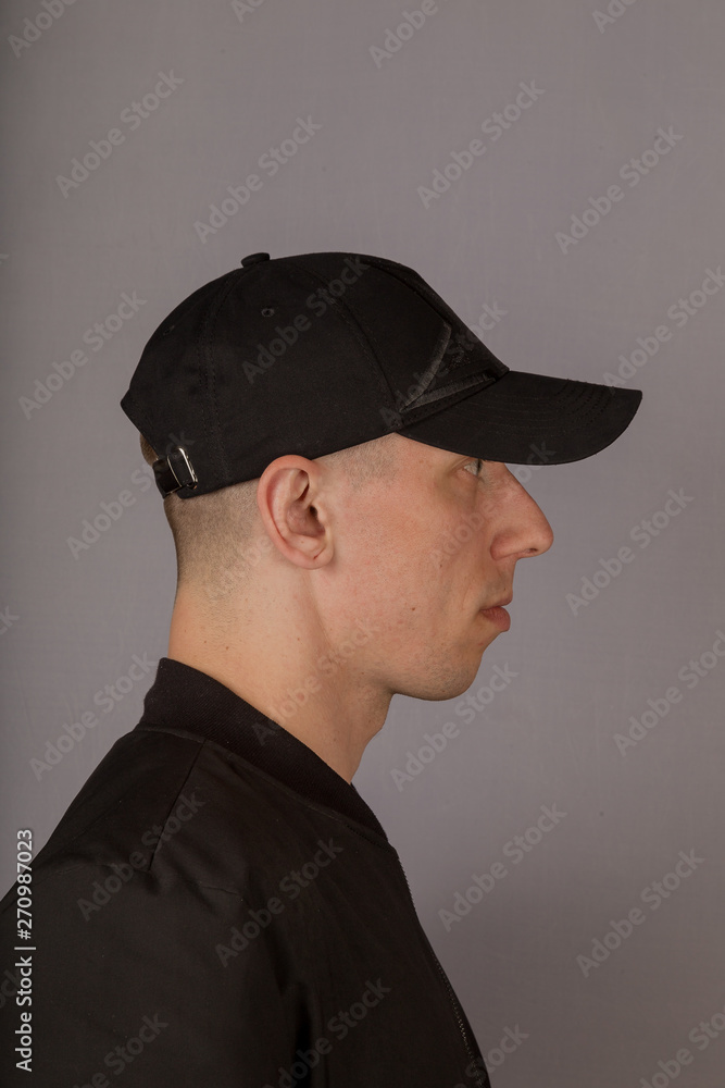 Handsome young man in a headdress on a gray background. Handsome young man in a headdress on a gray background.