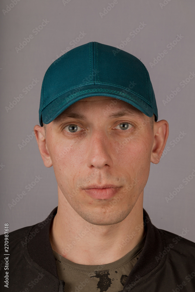 Handsome young man in a headdress on a gray background. Handsome young man in a headdress on a gray background.