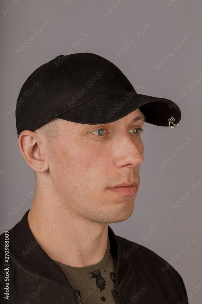 Handsome young man in a headdress on a gray background. Handsome young man in a headdress on a gray background.
