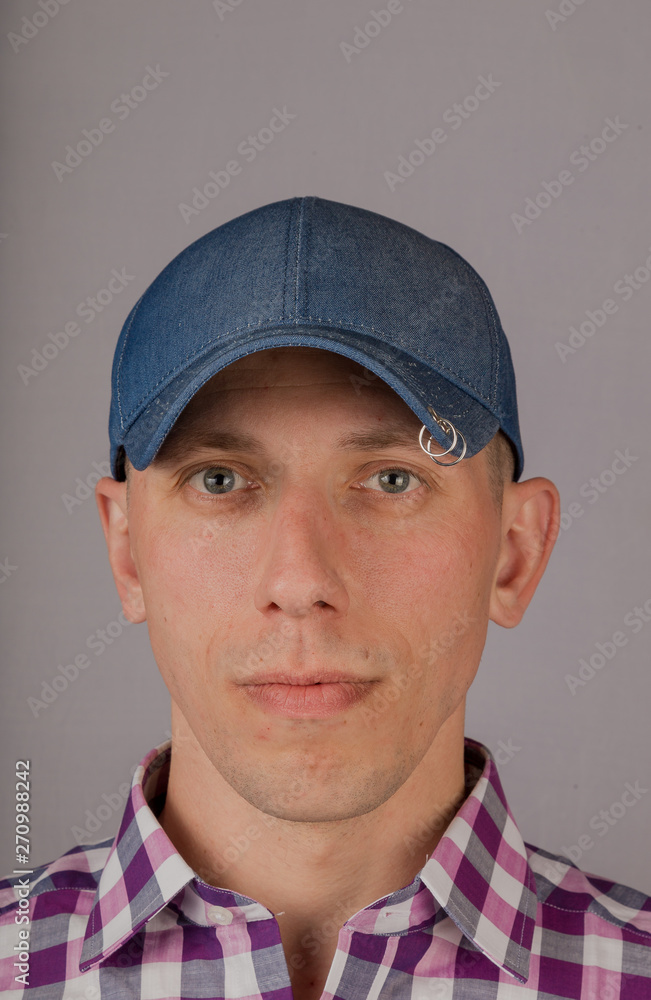 Handsome young man in a headdress on a gray background. Handsome young man in a headdress on a gray background.