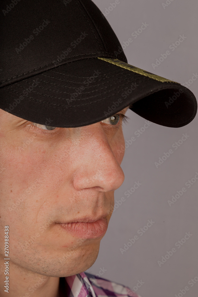 Handsome young man in a headdress on a gray background. Handsome young man in a headdress on a gray background.