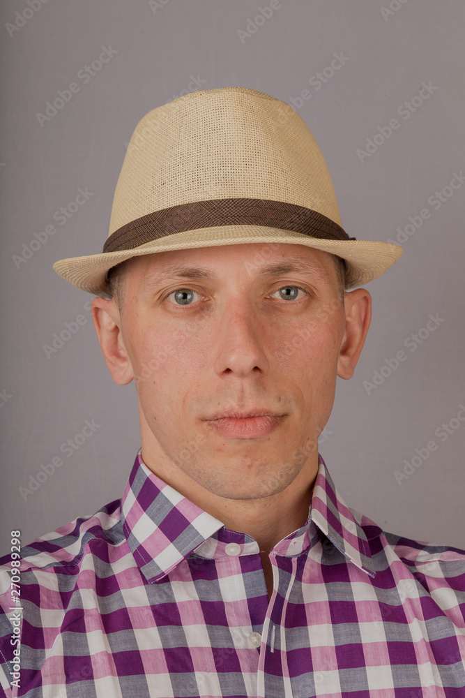 Handsome young man in a headdress on a gray background. Handsome young man in a headdress on a gray background.