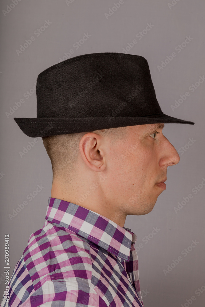 Handsome young man in a headdress on a gray background. Handsome young man in a headdress on a gray background.