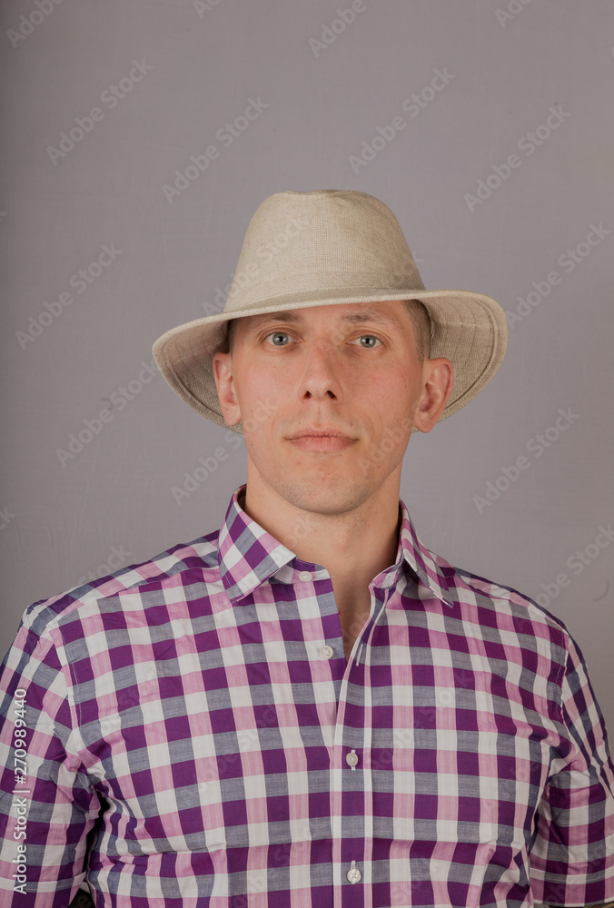 Handsome young man in a headdress on a gray background. Handsome young man in a headdress on a gray background.