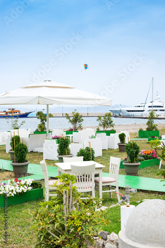 Cafe tables served with a white tablecloth near the sea coast for relaxing holidays vacations