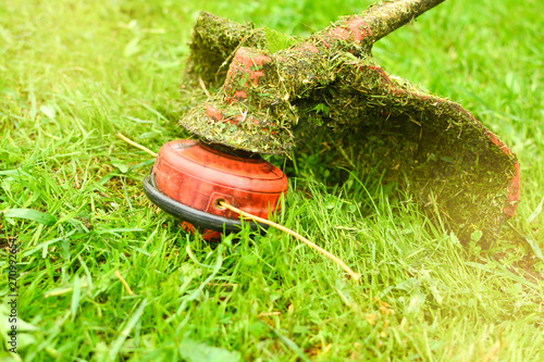 Trimmer close up mow the grass with a lawnmower. Gardening with a brush cutter Close-up. Lawn care with brush cutters