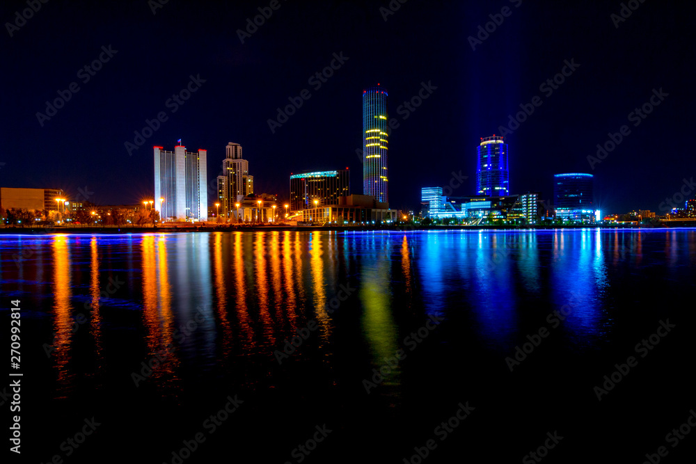 Cityscape of Yekaterinburg, Russia at night with lights reflections on water