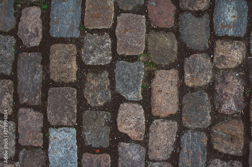 The texture of the old cobblestone and unusual stones. Patterned paving tiles cobblestone road for texture. Top view. Copy space. Can use as banner