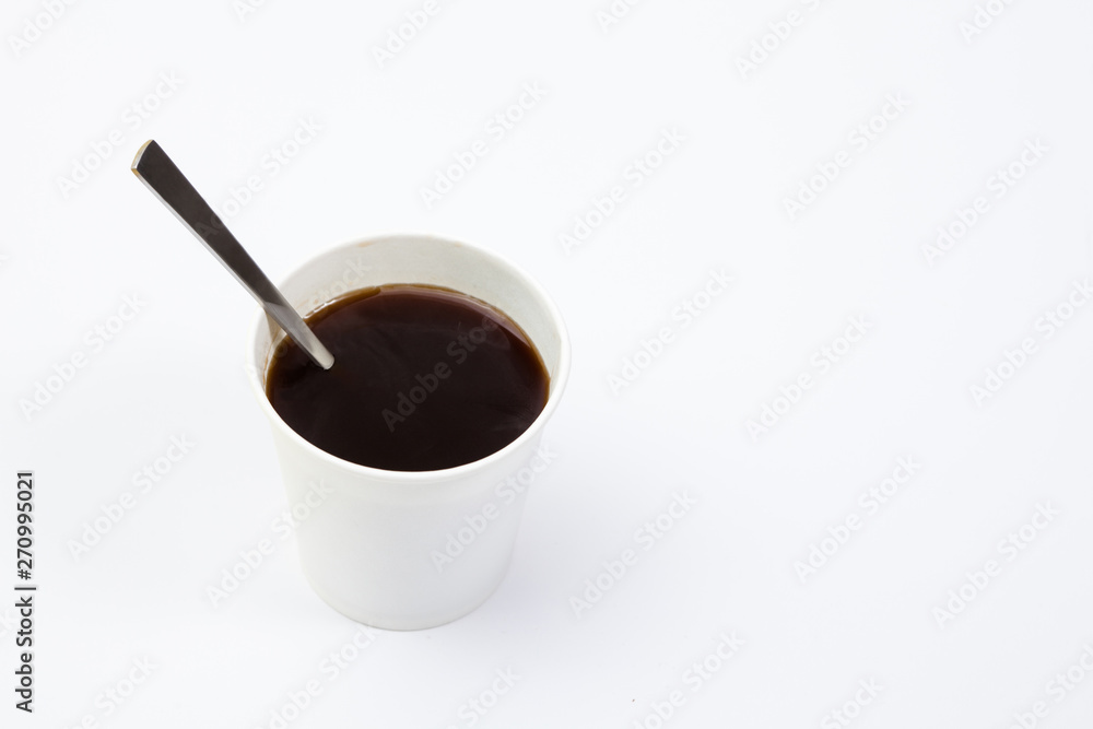 Paper cup of black coffee with spoon on white background Paper cup of black coffee with spoon on white background