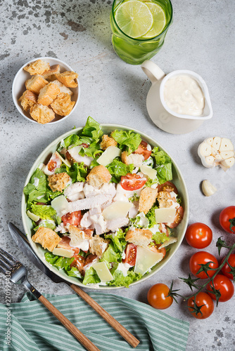 Caesar salad with chicken breast on gray background 
