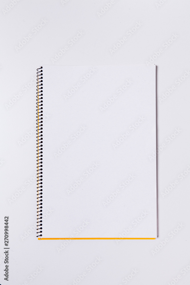 Yellow sticky post note on blank note pad Yellow sticky post note on blank note pad