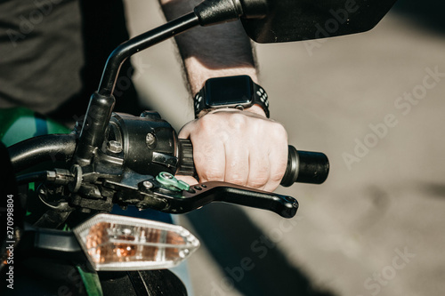 smart watch on the hand of a motorcyclist biker. modern transport have a motorcycle driver.