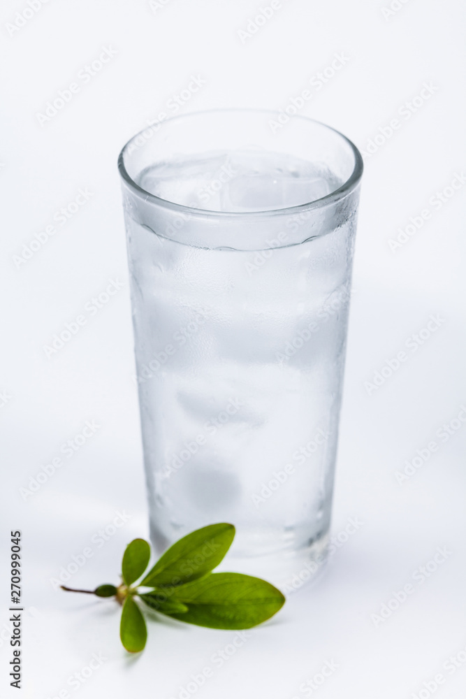 Glass of cold ice water with green leaf on white background Glass of cold ice water with green leaf on white background