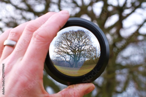 lens in handrevealing or inverting landscape behind