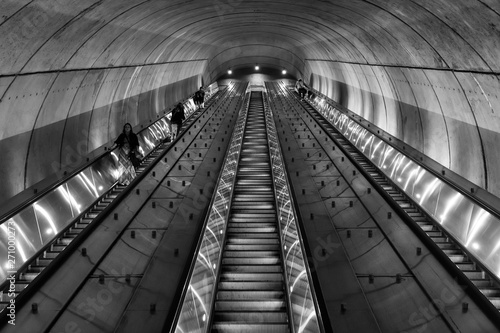 Tablou pe pânză Commuters take a long escalator out of an underground subway station in Washingt
