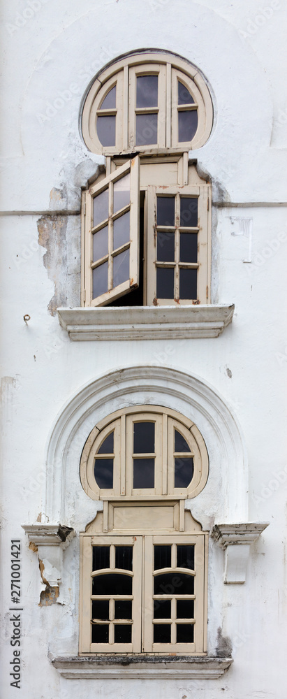 Fragment of the wall with windows of old colonial style building of Panggung Bandaraya DBKL (Malay for DBKL City Theatre) with oriental motifs at Kuala Lumpur, Malaysia. Fragment of the wall with windows of old colonial style building of Panggung Bandaraya DBKL (Malay for DBKL City Theatre) with oriental motifs at Kuala Lumpur, Malaysia.