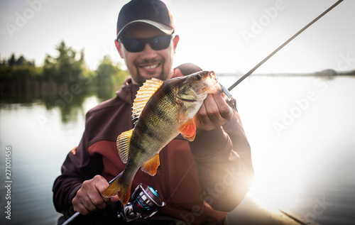 Fototapet Happy angler with perch fishing trophy.