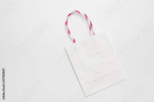 White kraft eco shopping bag with handles lying on a white background