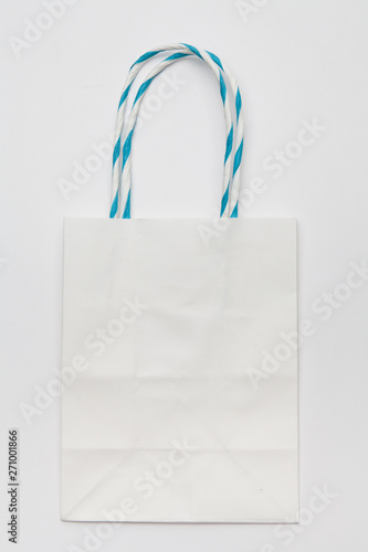 White kraft eco shopping bag with handles lying on a white background