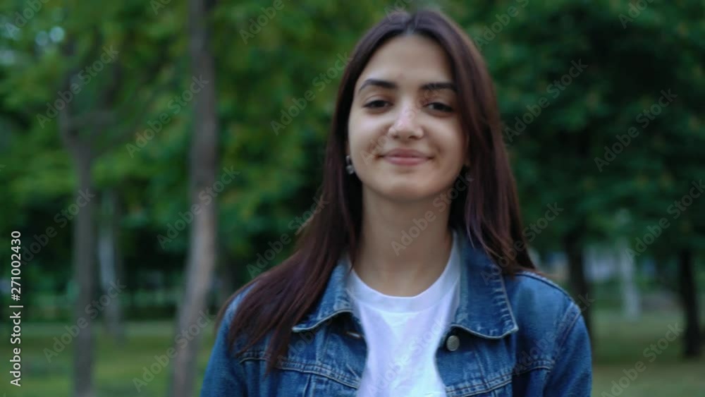 beautiful brunette young woman walking to camera in the park beautiful brunette young woman walking to camera in the park