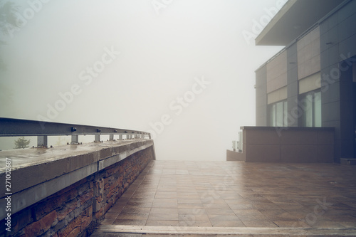 Foto Misty day on mountain range hotel yard tiles fence Old Mountain