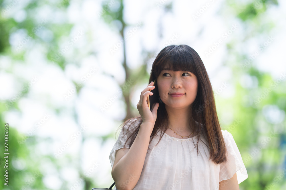 女性・スマホ・新緑 女性・スマホ・新緑