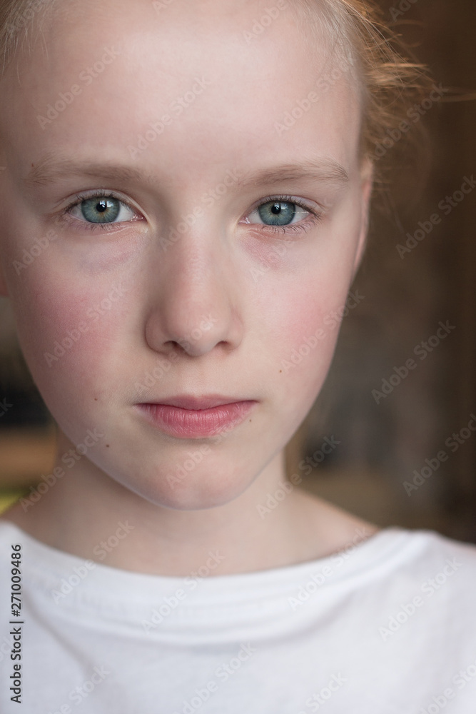 Cute Caucasian blond young girl angry frowns, studio portrait on brown background Cute Caucasian blond young girl angry frowns, studio portrait on brown background
