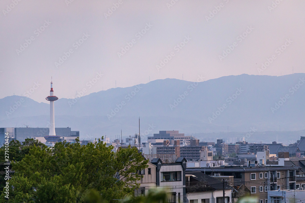 Large modern tower stands over buildings in typical Japanese neighborhood before sunset Large modern tower stands over buildings in typical Japanese neighborhood before sunset