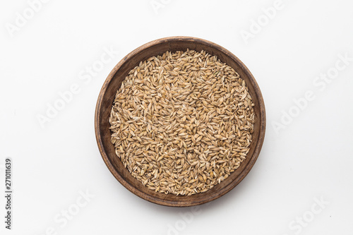 Barley grains in wooden plate isolated