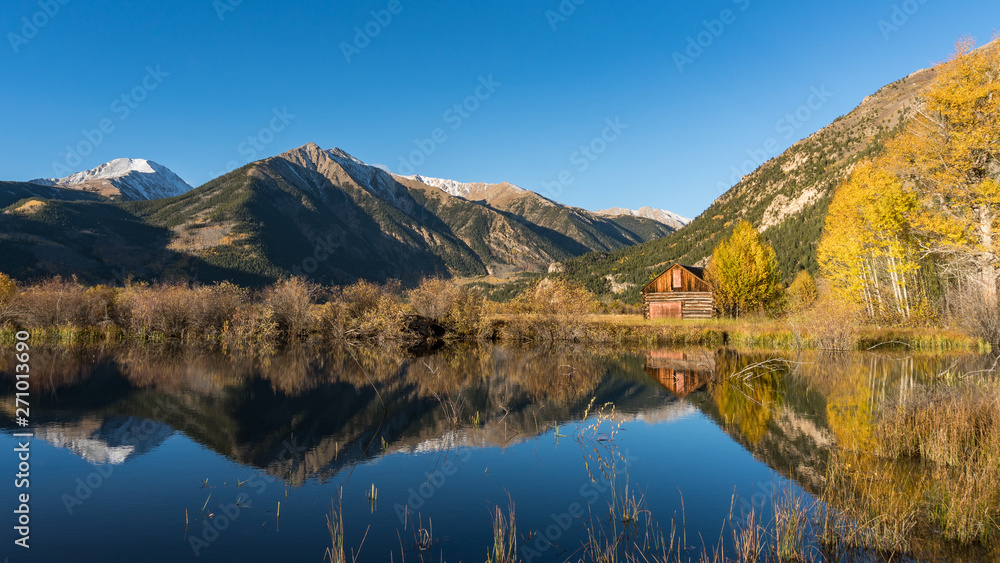Old cabin by lake in Autumn colors