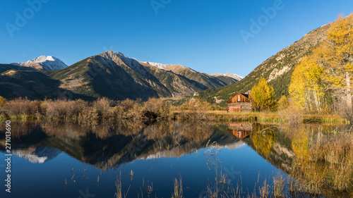 Fototapeta Naklejka Na Ścianę i Meble -  Old cabin by lake in Autumn colors