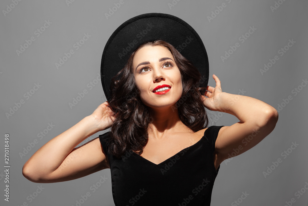 Profile portrait of a beautiful smiling lady wearing a black hat and looks up Profile portrait of a beautiful smiling lady wearing a black hat and looks up