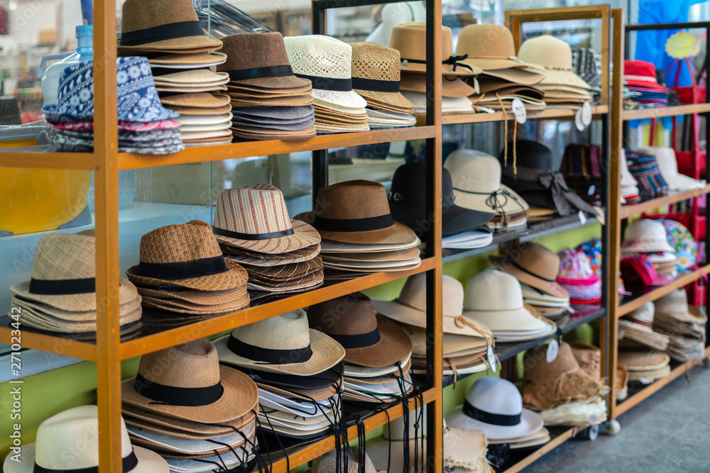 many summer hats and Panama hats lie on the counter in the shop for tourists. Summer, Thailand.
