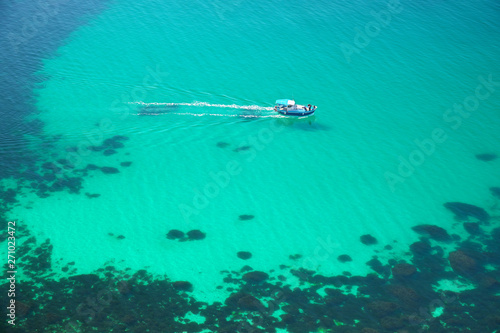 Boat on transparent sea surface. © GIS