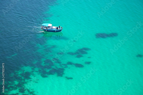 Boat on transparent sea surface.