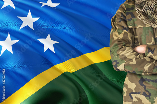 Crossed arms soldier with national waving flag on background - Solomon Islands Military theme.