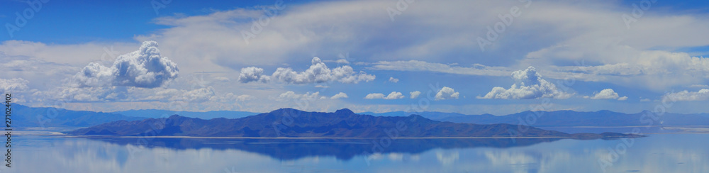 panorama of mountain reflecting in the water with blue sky and white clouds