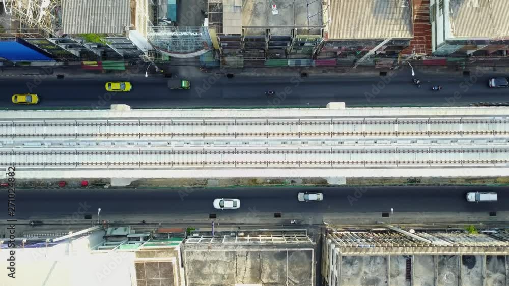 4K. Aerial view of skytrain railroad over two-way urban road in Bangkok, Thailand. Land transport railway in the city. 4K. Aerial view of skytrain railroad over two-way urban road in Bangkok, Thailand. Land transport railway in the city.