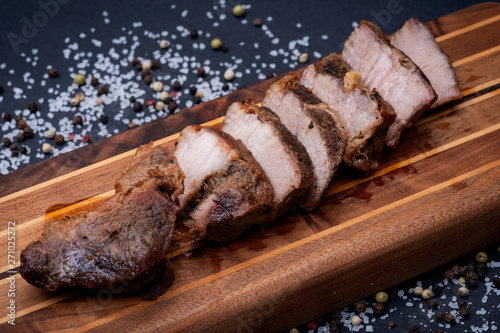 Oven Roasted Pork with spices on wooden cutting board.